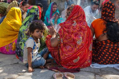Nepal Durbar Meydanı'nda geleneksel sari Hindu kadınlar ile bir çocuk oturur