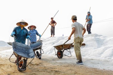 İşçiler tuz Nha Trang, VI Hon Khoi tuz alanlarında, kaldırma