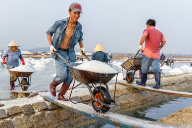 Bir adam Nha Trang, Vietnam Hon Khoi tuz alanlarında çalışıyor