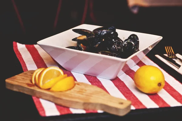 Mejillones en un tazón blanco servido con limón — Foto de Stock