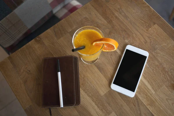 Смартфон, ноутбук и стакан апельсинового сока — стоковое фото