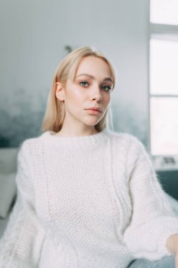 Sevimli kız okuma bir kitap, konfor ve yenilikçi kavramı ile çay, rahat bir sandalye üzerinde