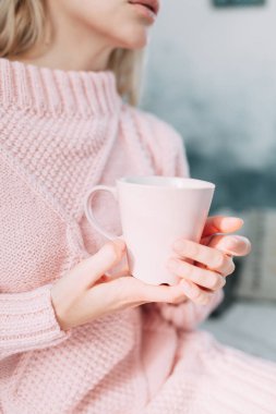 Sevimli kız okuma bir kitap, konfor ve yenilikçi kavramı ile çay, rahat bir sandalye üzerinde