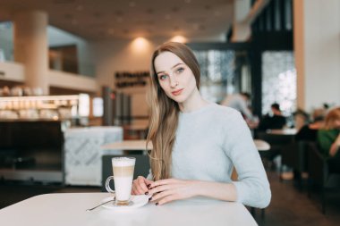 Dizüstü bilgisayar ile kafe teras reklam, pozitif kız öğrencinin öğrenme ve ders oluşturma hakkında düşünme için kopya alanı yakınında oturan proje planlama Eyewear dalgın genç kadın