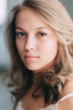 Modern güneşli daire sabahları yatakta oldukça genç kız portresi. Yudumlarken ve gülümseyen, kahve içme ve yerde yatarken