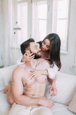 Genç mutlu çift evde, sarılma ve öpüşme vardır. Sevilen olanlar pijama deli ve gülmek güzel güneşli sabah.