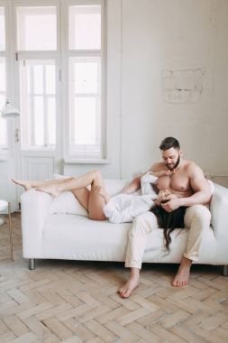 Genç mutlu çift evde, sarılma ve öpüşme vardır. Sevilen olanlar pijama deli ve gülmek güzel güneşli sabah.