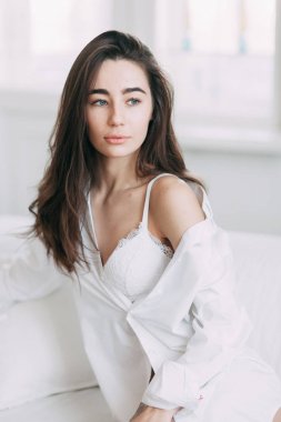 Genç mutlu çift evde, sarılma ve öpüşme vardır. Sevilen olanlar pijama deli ve gülmek güzel güneşli sabah.