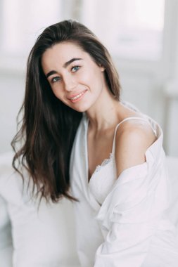 Genç mutlu çift evde, sarılma ve öpüşme vardır. Sevilen olanlar pijama deli ve gülmek güzel güneşli sabah.