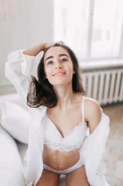 Genç mutlu çift evde, sarılma ve öpüşme vardır. Sevilen olanlar pijama deli ve gülmek güzel güneşli sabah.