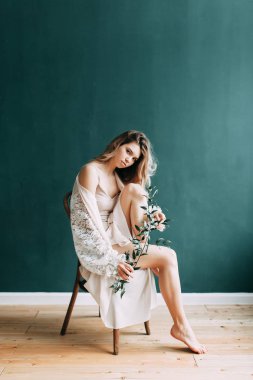 Kadının küçük özel odası ve bir çelenk ve onu elinde bir buket ile gelinlik genç güzel gelin. Londra düğün trendleri, şık photoshoot