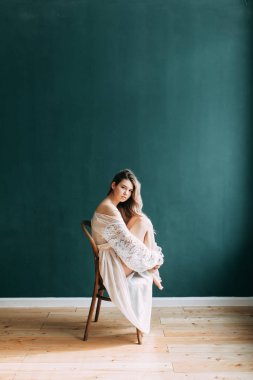 Kadının küçük özel odası ve bir çelenk ve onu elinde bir buket ile gelinlik genç güzel gelin. Londra düğün trendleri, şık photoshoot