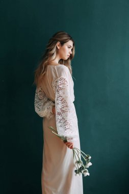 Kadının küçük özel odası ve bir çelenk ve onu elinde bir buket ile gelinlik genç güzel gelin. Londra düğün trendleri, şık photoshoot