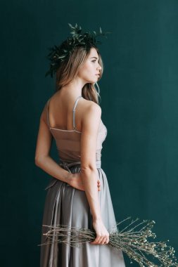 Kadının küçük özel odası ve bir çelenk ve onu elinde bir buket ile gelinlik genç güzel gelin. Londra düğün trendleri, şık photoshoot