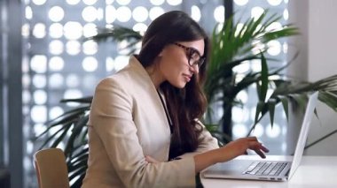 Bir kafede çalışan güzel şirin iş kız serbest meslek. Yazarak ve gülümseyen laptop bakar. İyi bir anlaşma, başarılı iş ve kariyer. Instant messengers iletişim