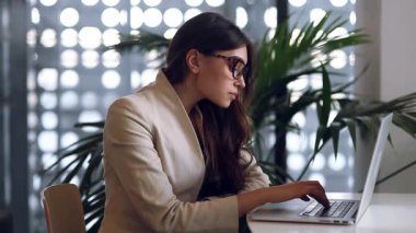 Bir kafede çalışan güzel şirin iş kız serbest meslek. Yazarak ve gülümseyen laptop bakar. İyi bir anlaşma, başarılı iş ve kariyer. Instant messengers iletişim