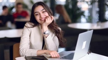 Holding ve kahve içme bir dizüstü bilgisayar üzerinde çalışan iş kız. Serbest meslek restoranda, başarılı kadın. Office durum, mutlu başarı ve güzel bir görünüm.