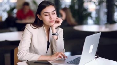 Holding ve kahve içme bir dizüstü bilgisayar üzerinde çalışan iş kız. Serbest meslek restoranda, başarılı kadın. Office durum, mutlu başarı ve güzel bir görünüm.