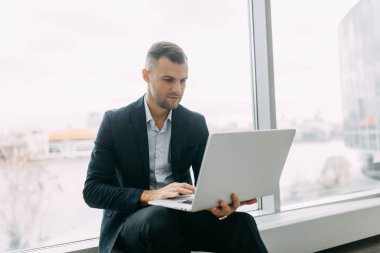 Ofis işi, iş durumu. Dizüstü bilgisayarı olan genç bir iş adamı.. 