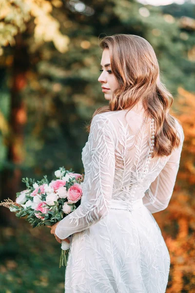 Autumn wedding in European style. Beautiful bride in white dress in the Park.