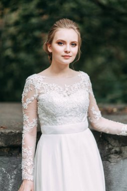 Avrupa tarzında zarif bir tören. Ormanda uçan beyaz elbiseli güzel gelin. 