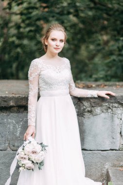 Avrupa tarzında zarif bir tören. Ormanda uçan beyaz elbiseli güzel gelin. 