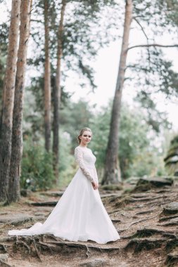 Avrupa tarzında zarif bir tören. Ormanda uçan beyaz elbiseli güzel gelin. 