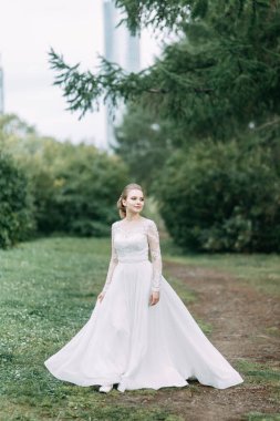 Avrupa tarzında zarif bir tören. Ormanda uçan beyaz elbiseli güzel gelin. 