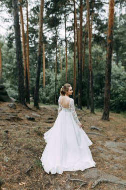 Avrupa tarzında zarif bir tören. Ormanda uçan beyaz elbiseli güzel gelin. 