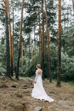 Avrupa tarzında zarif bir tören. Ormanda uçan beyaz elbiseli güzel gelin. 