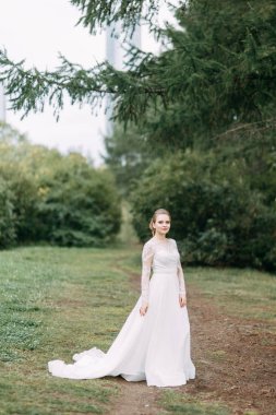 Avrupa tarzında zarif bir tören. Ormanda uçan beyaz elbiseli güzel gelin. 