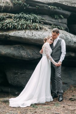 Avrupa tarzında modern bir tören. Atmosferik ormanda kayalarla güzel bir çift.. 