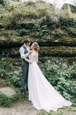 Avrupa tarzında modern bir tören. Atmosferik ormanda kayalarla güzel bir çift.. 