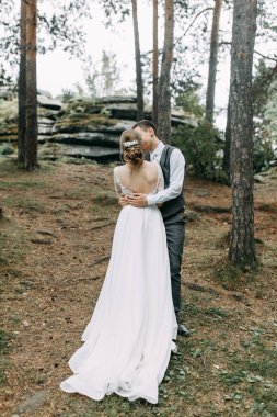 Avrupa tarzında modern bir tören. Atmosferik ormanda kayalarla güzel bir çift.. 