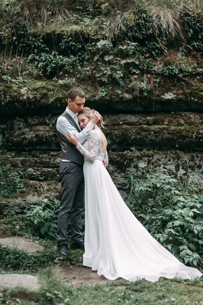 欧洲风格的现代仪式 美丽的新婚夫妇在有岩石的大气森林里 — 图库照片