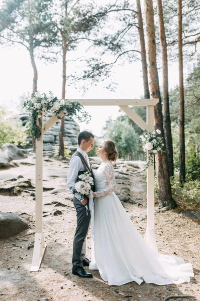 公園の日没時に美しいカップル 森の中のアーチと結婚式 — ストック写真