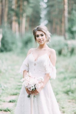 Avrupa tarzında zarif bir tören. Ormanda uçan beyaz elbiseli güzel gelin. 