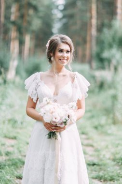Avrupa tarzında zarif bir tören. Ormanda uçan beyaz elbiseli güzel gelin. 
