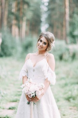 Avrupa tarzında zarif bir tören. Ormanda uçan beyaz elbiseli güzel gelin. 