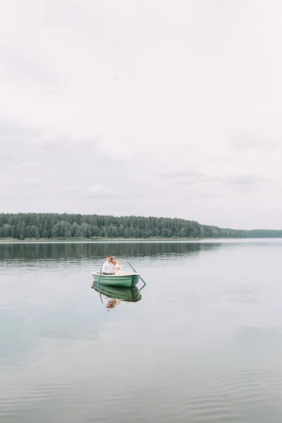 Stylish wedding in European style. Happy couple on a boat on the lake.