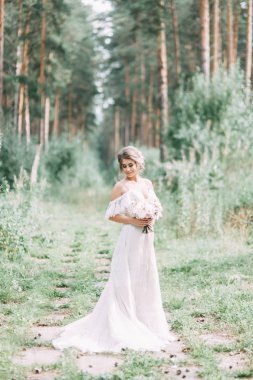 Avrupa tarzında zarif bir tören. Ormanda uçan beyaz elbiseli güzel gelin. 