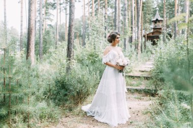 Avrupa tarzında zarif bir tören. Ormanda uçan beyaz elbiseli güzel gelin. 