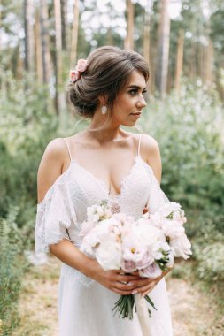 Avrupa tarzında zarif bir tören. Ormanda uçan beyaz elbiseli güzel gelin. 