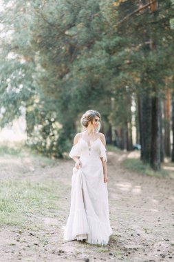 Avrupa tarzında zarif bir tören. Ormanda uçan beyaz elbiseli güzel gelin. 