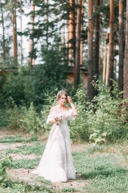 Avrupa tarzında zarif bir tören. Ormanda uçan beyaz elbiseli güzel gelin. 
