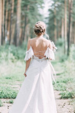 Avrupa tarzında zarif bir tören. Ormanda uçan beyaz elbiseli güzel gelin. 