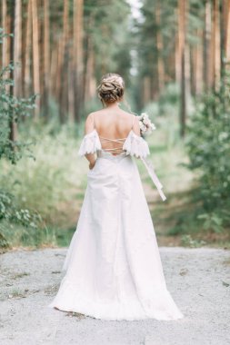 Avrupa tarzında zarif bir tören. Ormanda uçan beyaz elbiseli güzel gelin. 