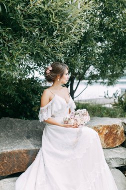 Doğada Avrupa tarzı şık bir düğün. Göldeki iskelede mutlu gelin. 