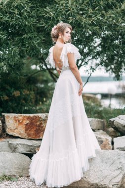 Doğada Avrupa tarzı şık bir düğün. Göldeki iskelede mutlu gelin. 