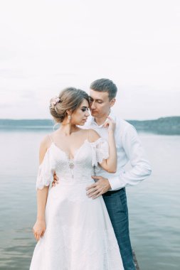 Günbatımında şık bir Avrupa düğünü. Göl kıyısındaki mutlu çift. 